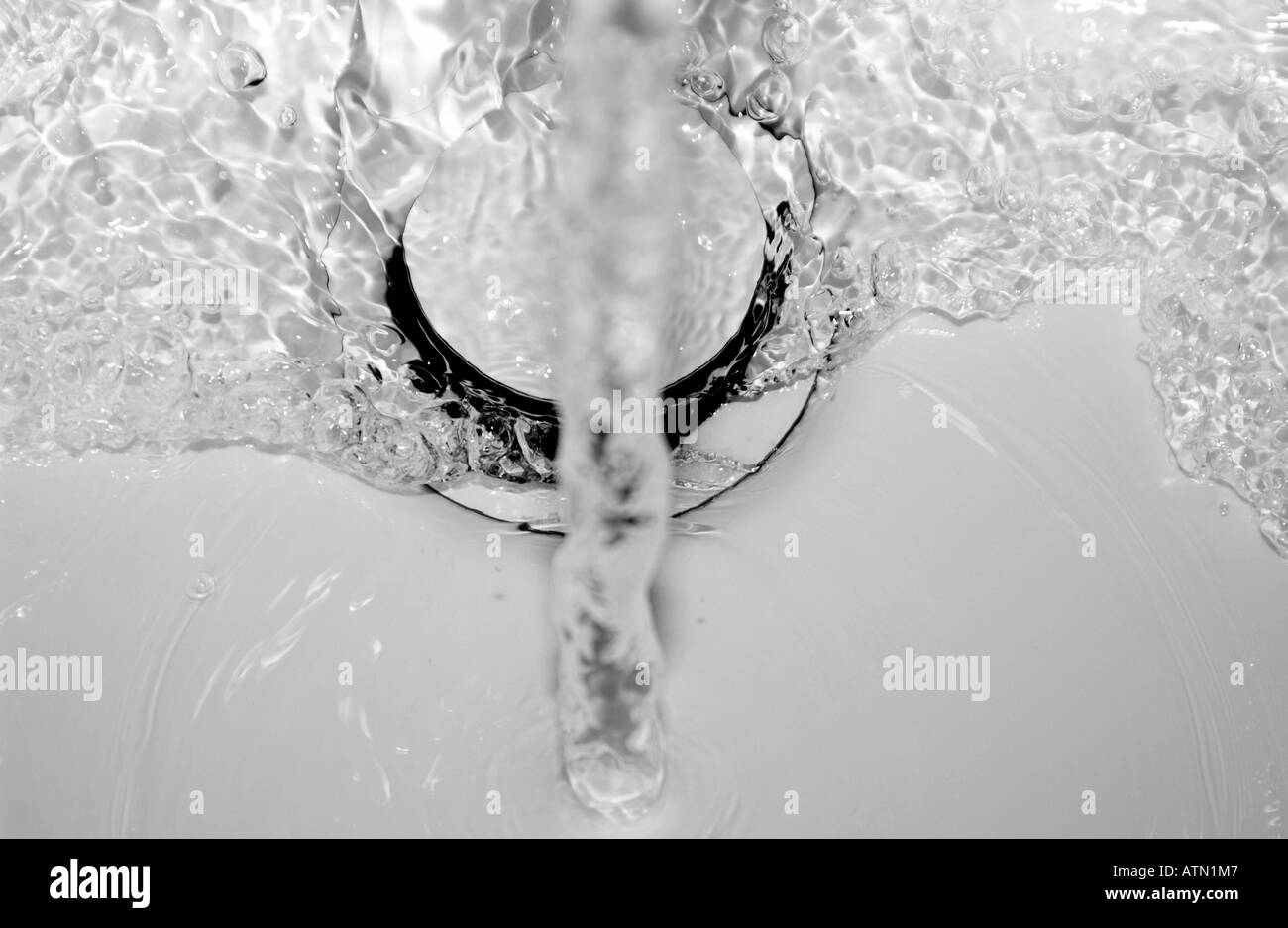 water running down a plug hole in a white sink or bath Stock Photo Alamy