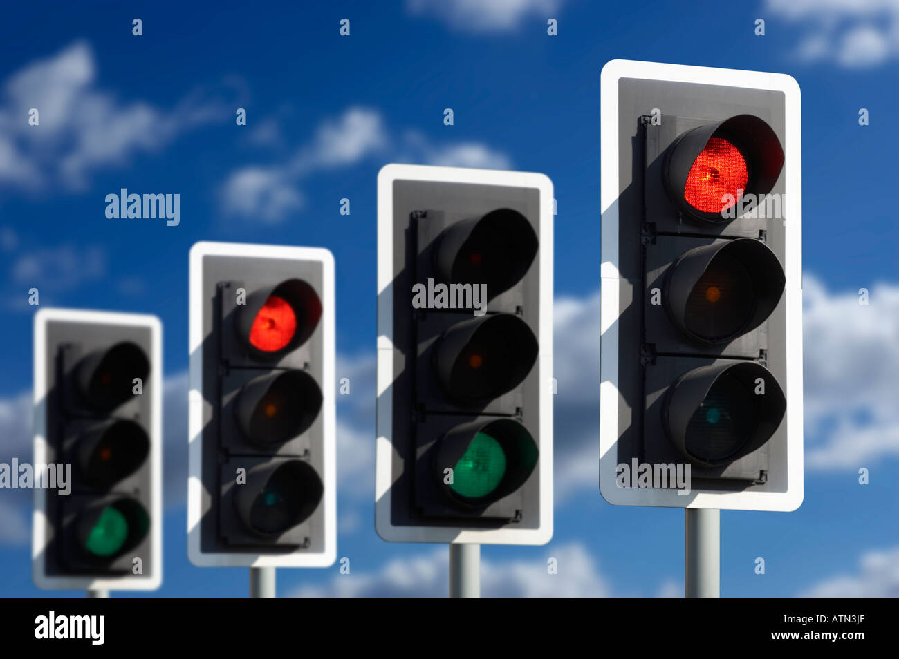 ROW OF FOUR ROAD TRAFFIC LIGHTS SHOWING ALTERNATE RED AND GREEN Stock Photo