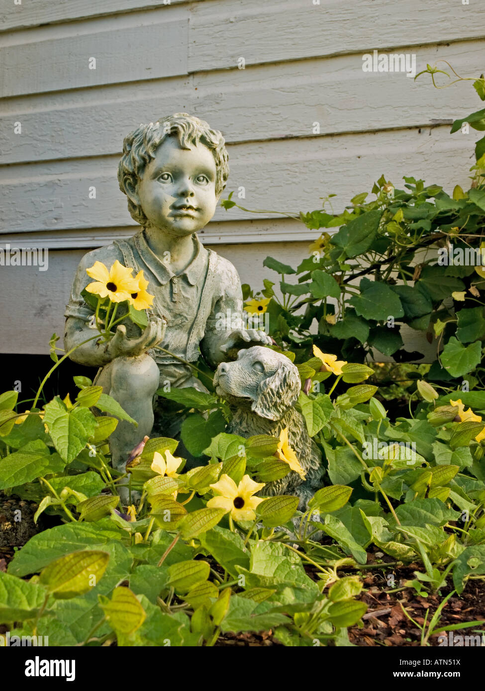 A garden statue with flowers growing on it Stock Photo Alamy