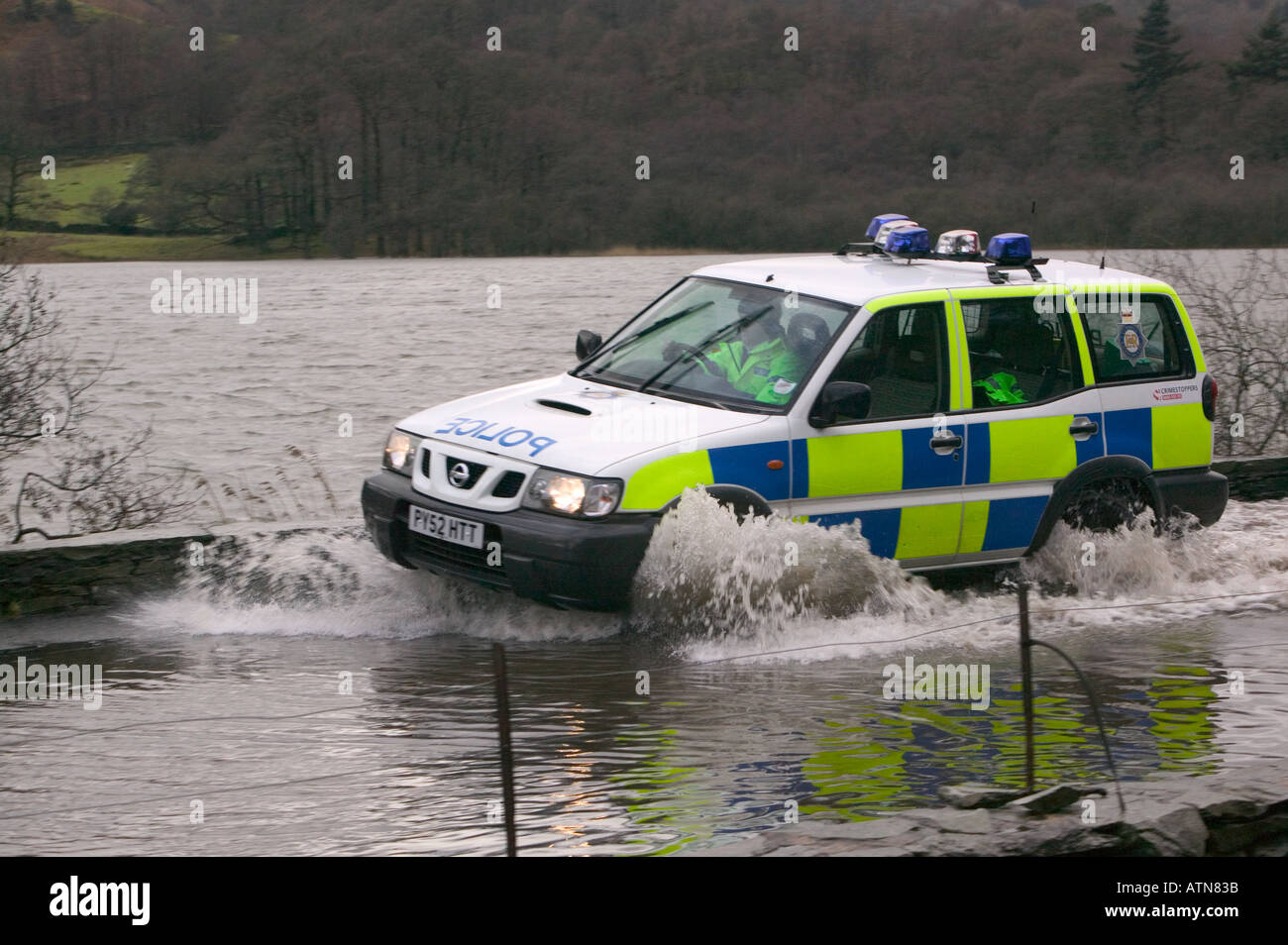 police car drives through floodwater at Rydal Lake district Stock Photo