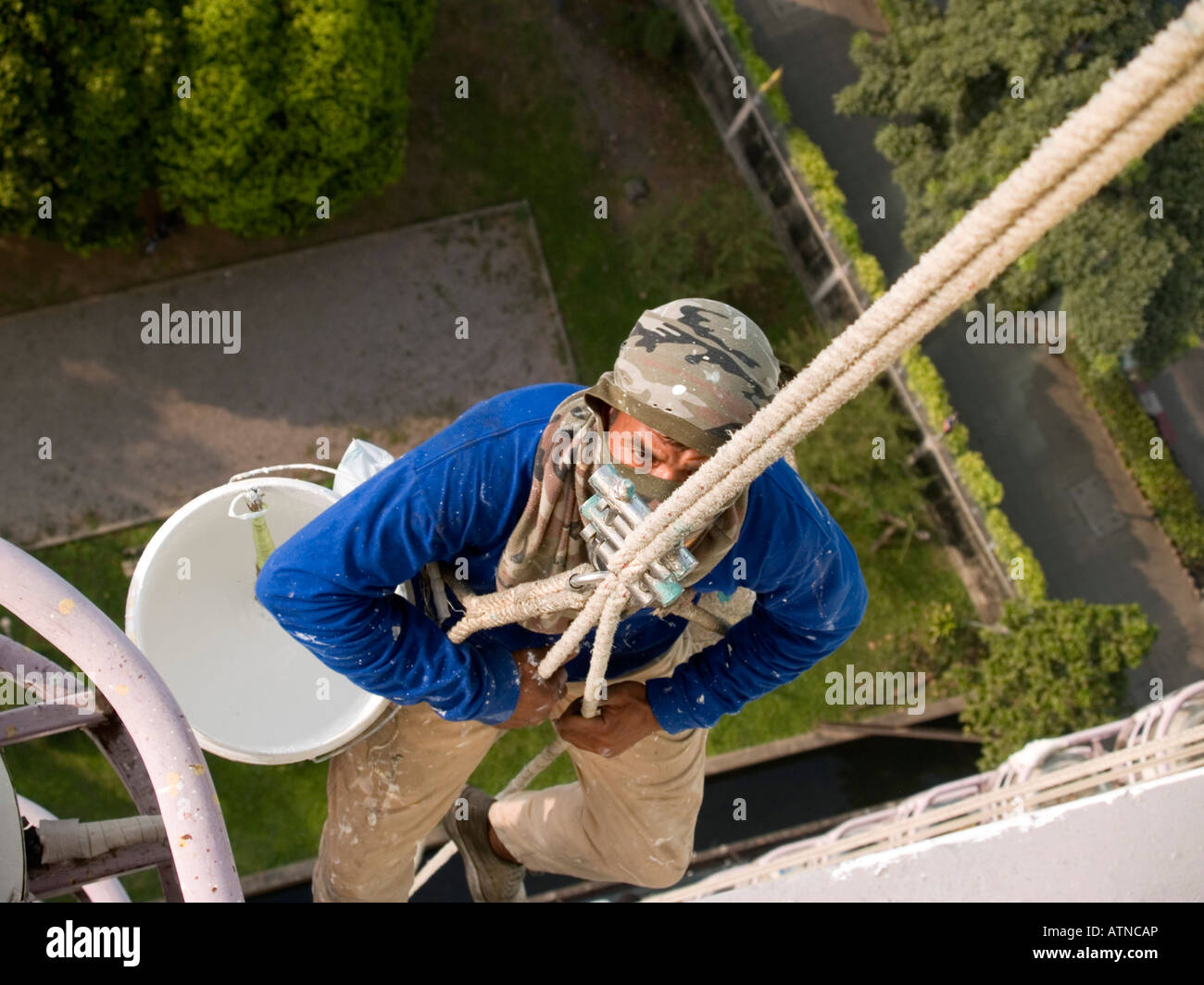painter working on highrise in Bangkok Stock Photo