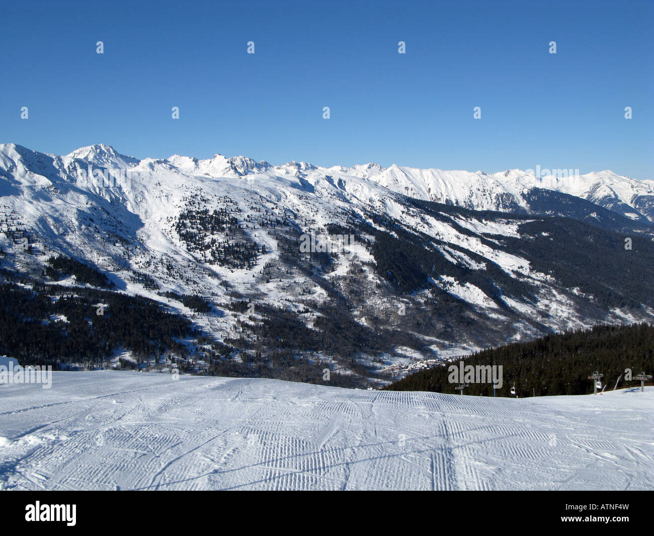 A view across snow covered mountains from a ski run near the resort of Meribel in France Stock Photo