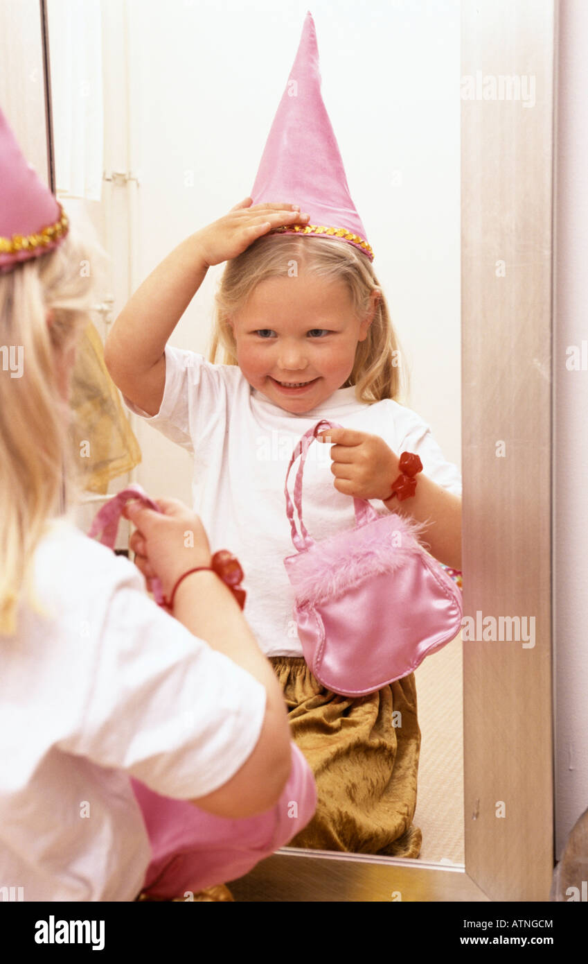 Little girl is dressing like a princess in front of the mirror Stock Photo