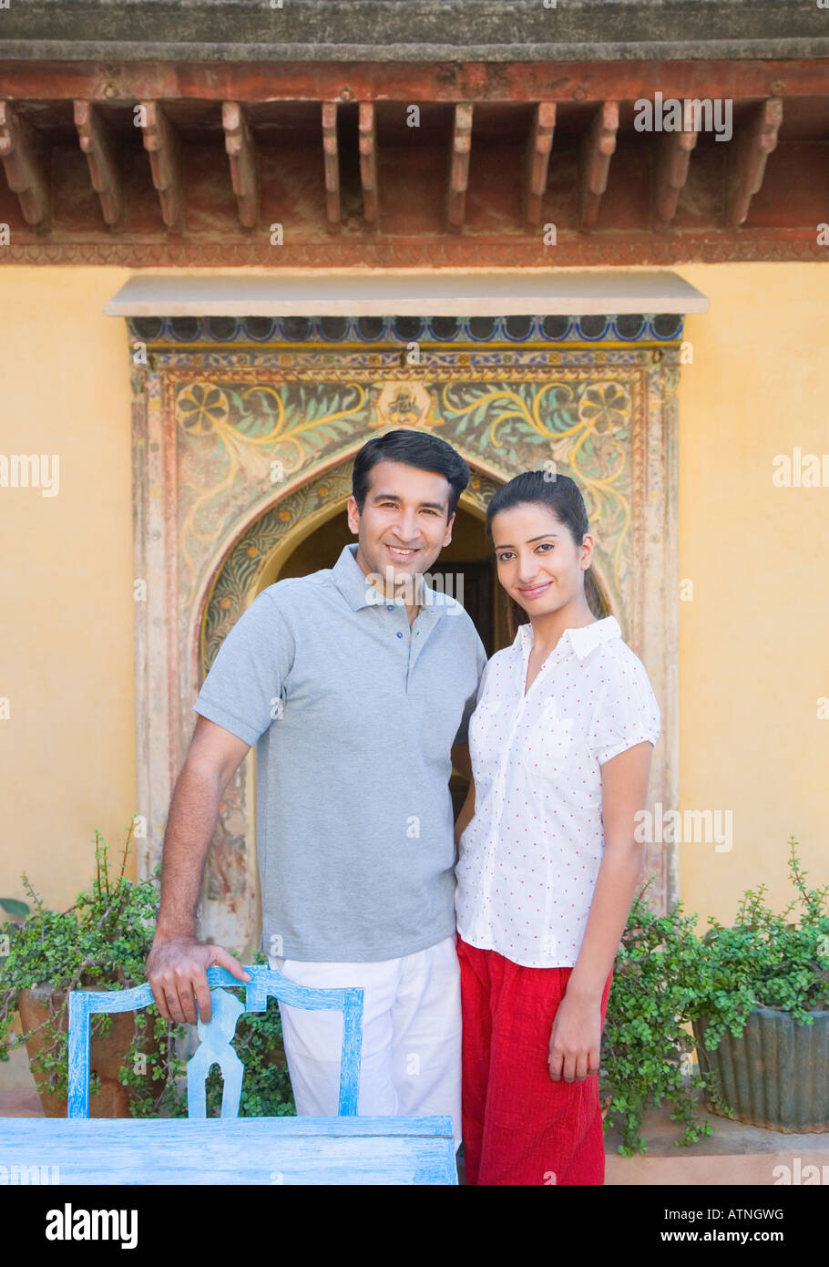 Portrait of a mid adult man standing with a young woman and smiling ...