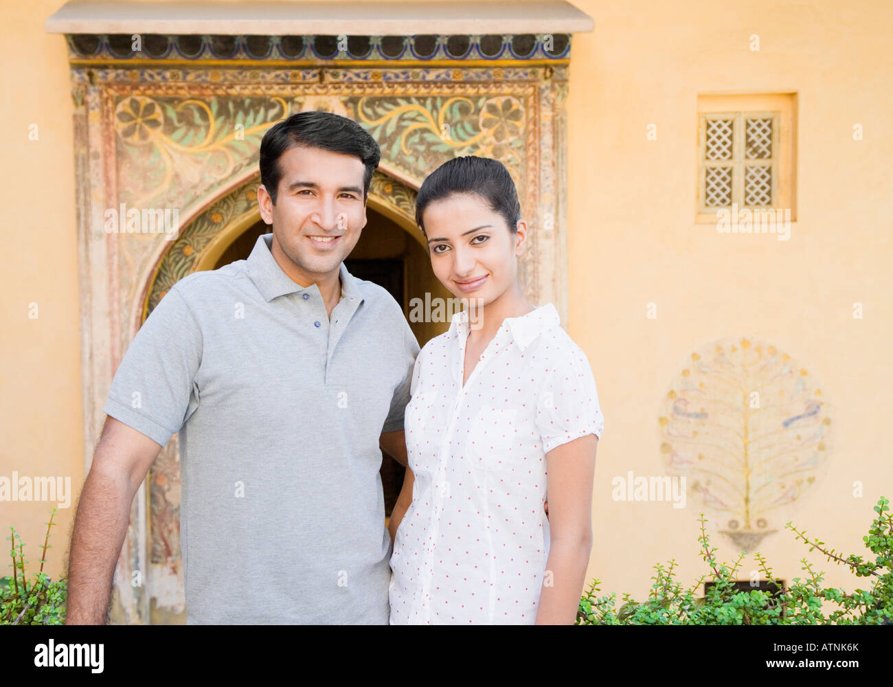 Portrait of a mid adult man standing with a young woman and smiling ...