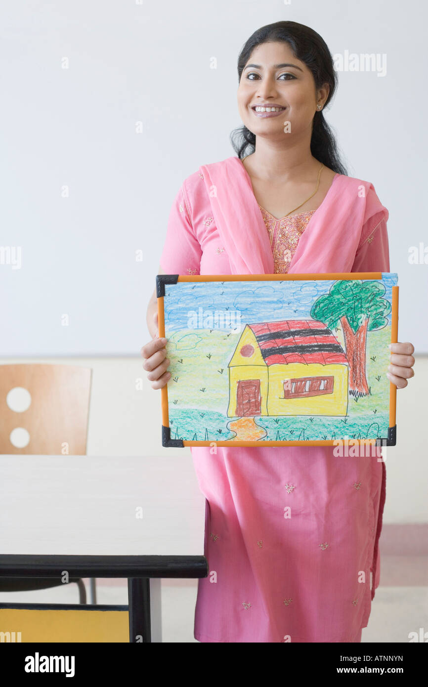 Portrait of a teacher holding a child's drawing and smiling Stock Photo ...