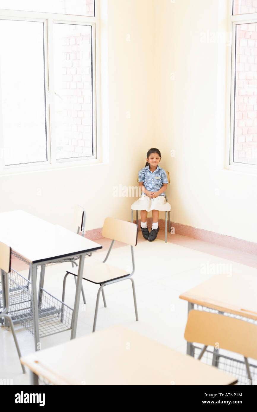 Schoolgirl sitting on a chair in a classroom Stock Photo - Alamy