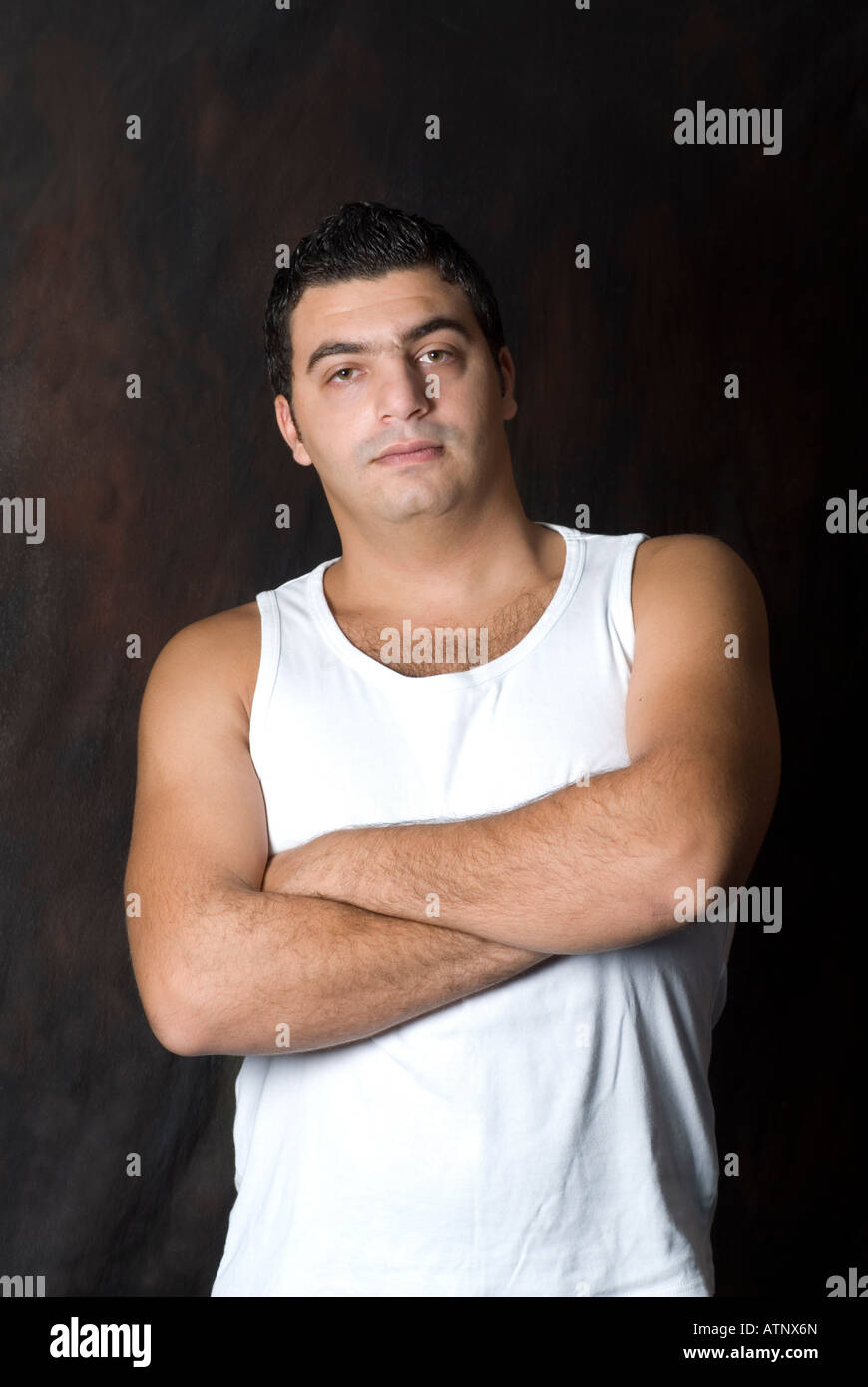 Man in white tank top arms folded Stock Photo Alamy