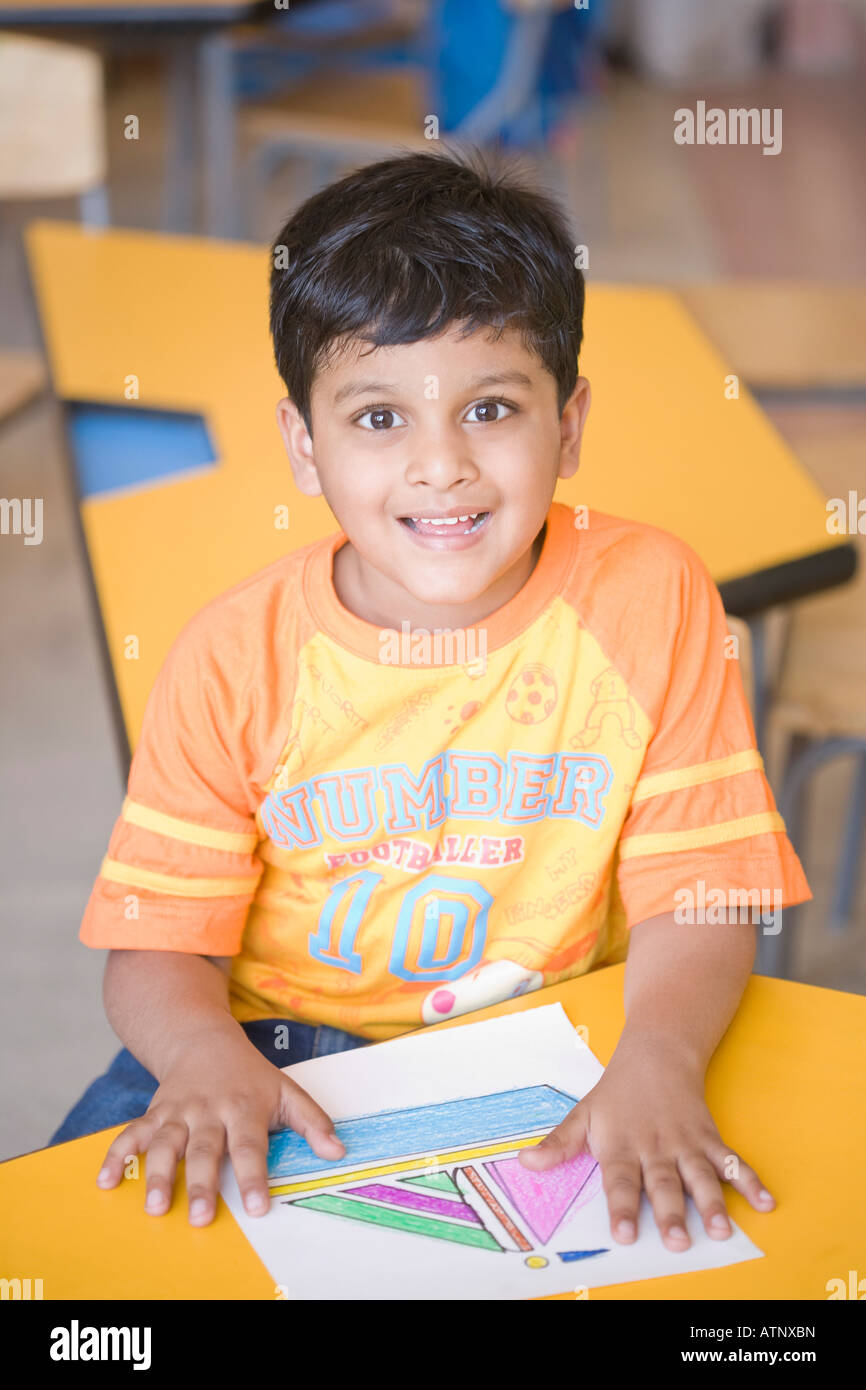 Portrait of a schoolboy sitting in a classroom and smiling Stock Photo ...