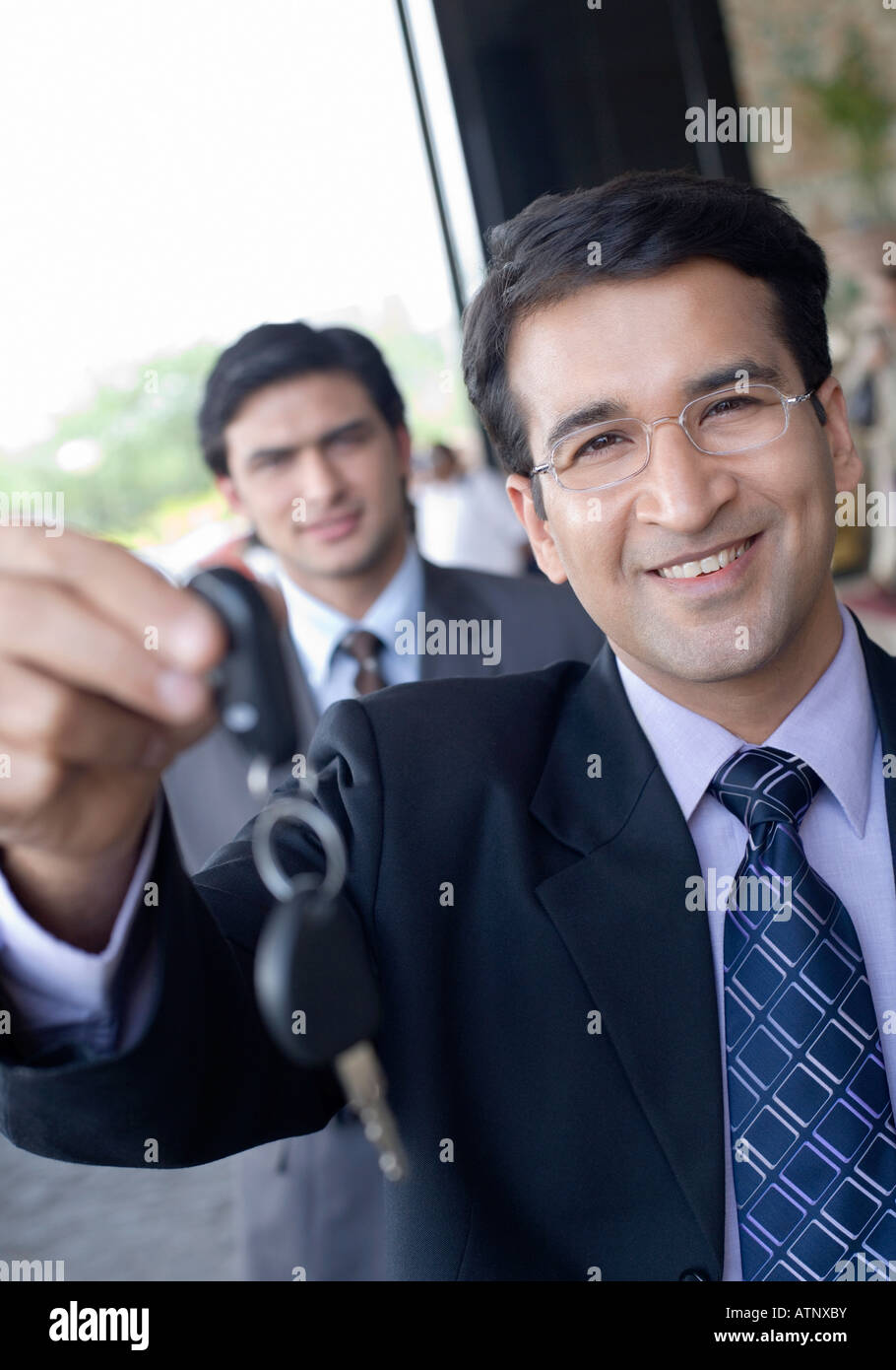 Portrait of a businessman showing a key and smiling Stock Photo - Alamy