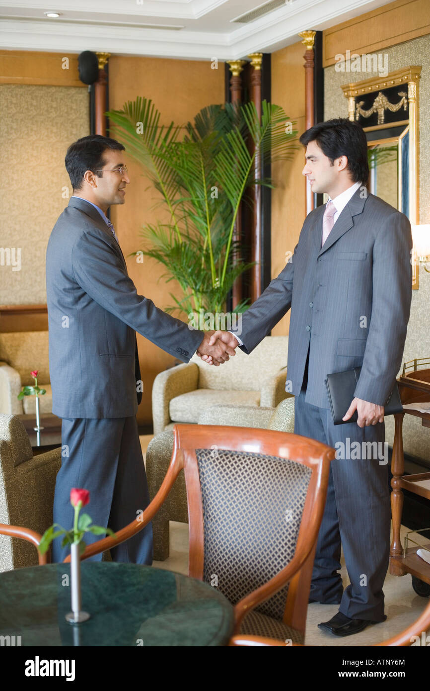 Side profile of two businessmen shaking hands Stock Photo - Alamy