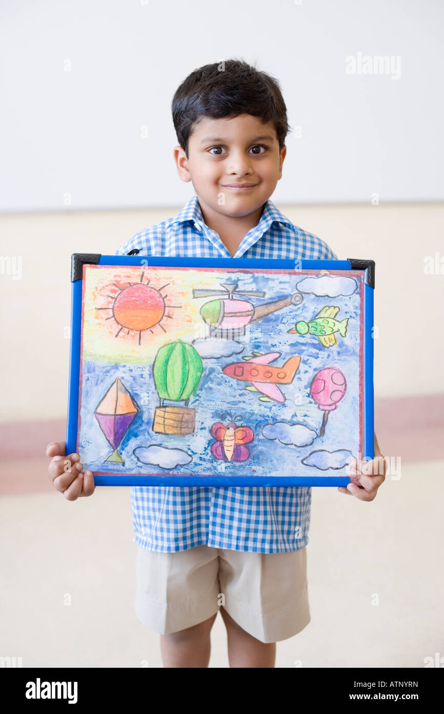 Portrait of a schoolboy holding a painting and smiling Stock Photo