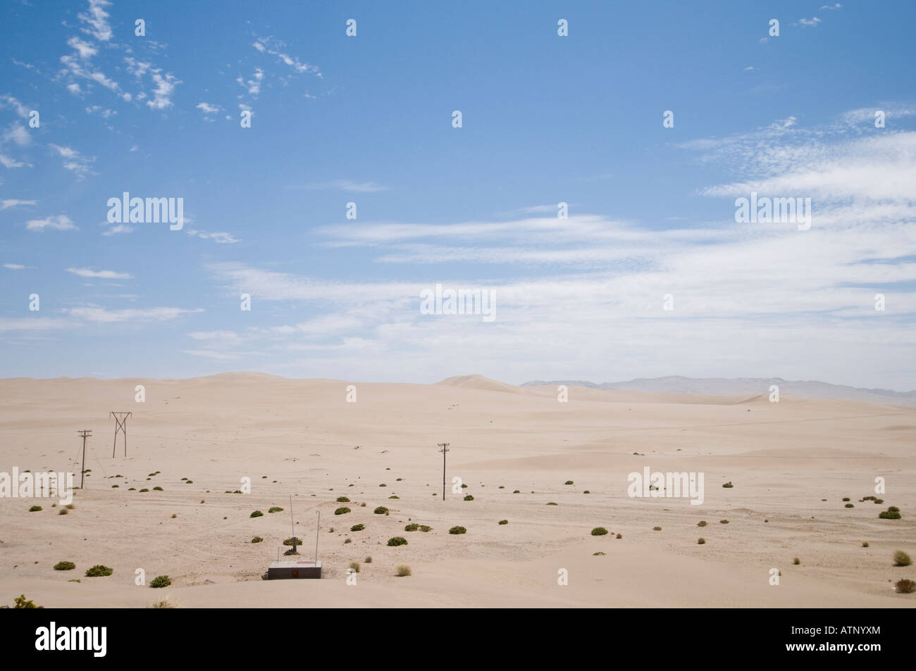 Sand in the Namib desert with telephone poles and power lines in Namibia Stock Photo
