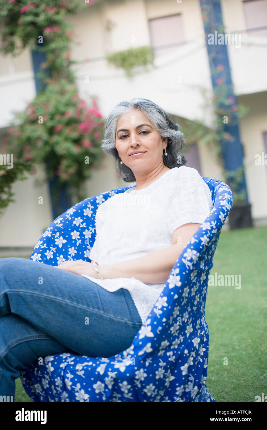 Portrait of a mature woman sitting on a chair Stock Photo - Alamy