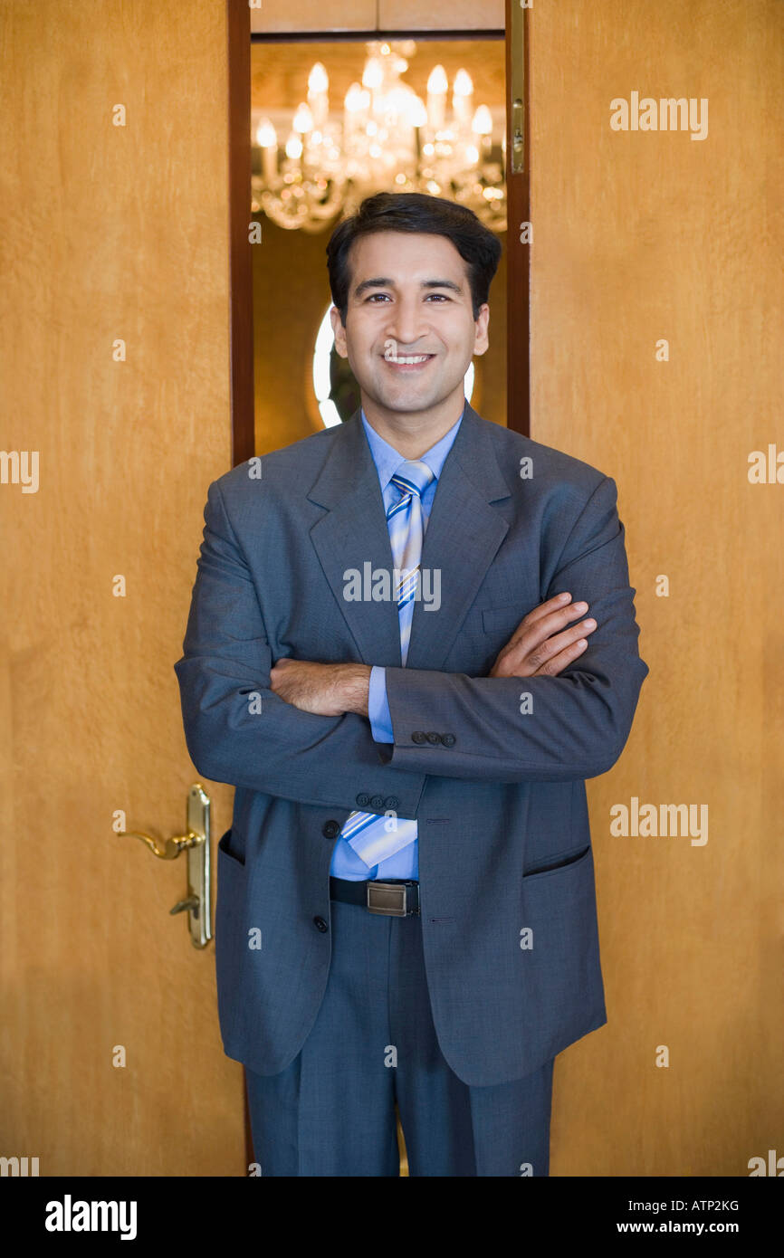 Portrait of a businessman standing with his arms crossed and smiling ...