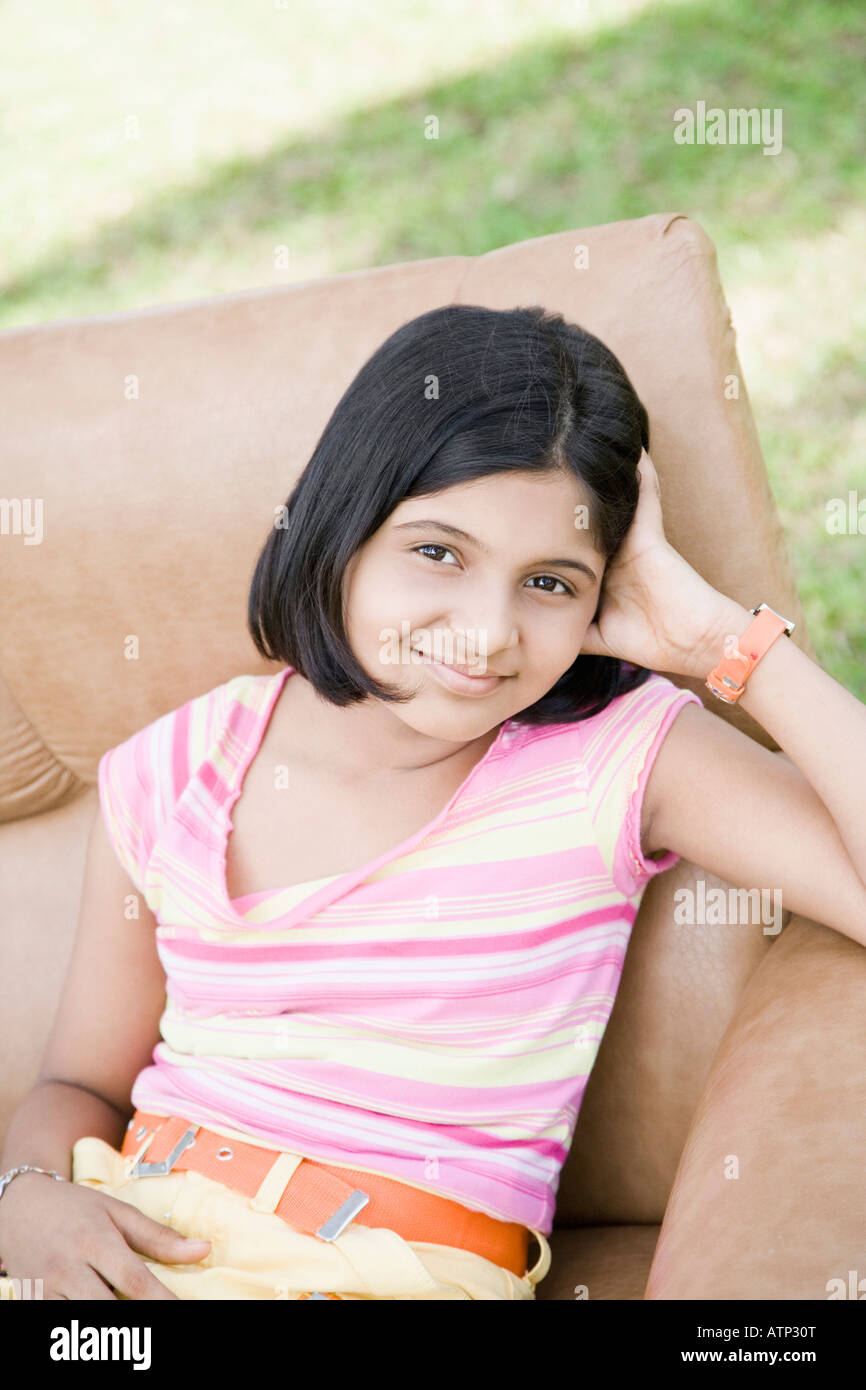 Portrait of a girl sitting in an armchair and smiling Stock Photo - Alamy