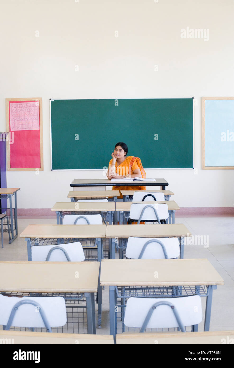 Female teacher sitting in an empty classroom Stock Photo Alamy