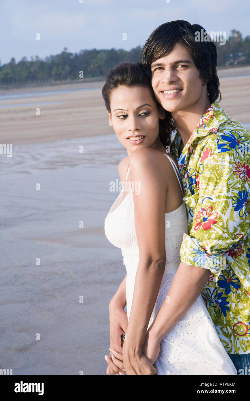 Portrait of a young man embracing a young woman on the beach Stock ...