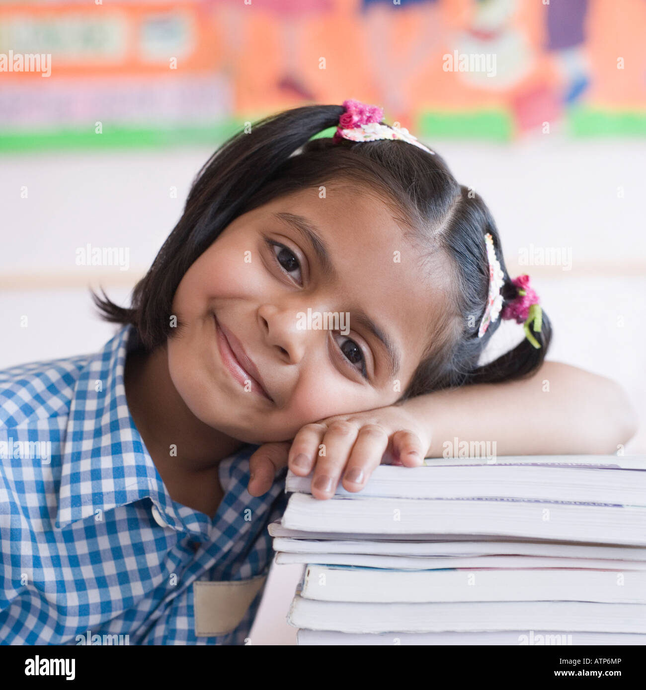 Portrait of a schoolgirl leaning on a stack of books and smirking Stock ...