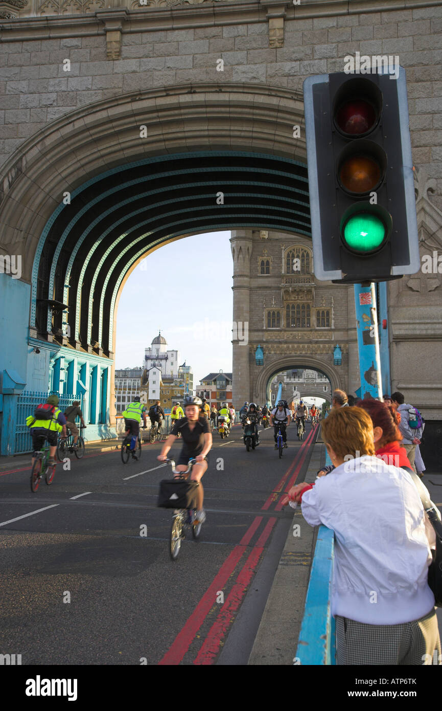 Cyclist at head of queue cycling towards each other from both sides after Tower Bridge has lowered London UK Stock Photo