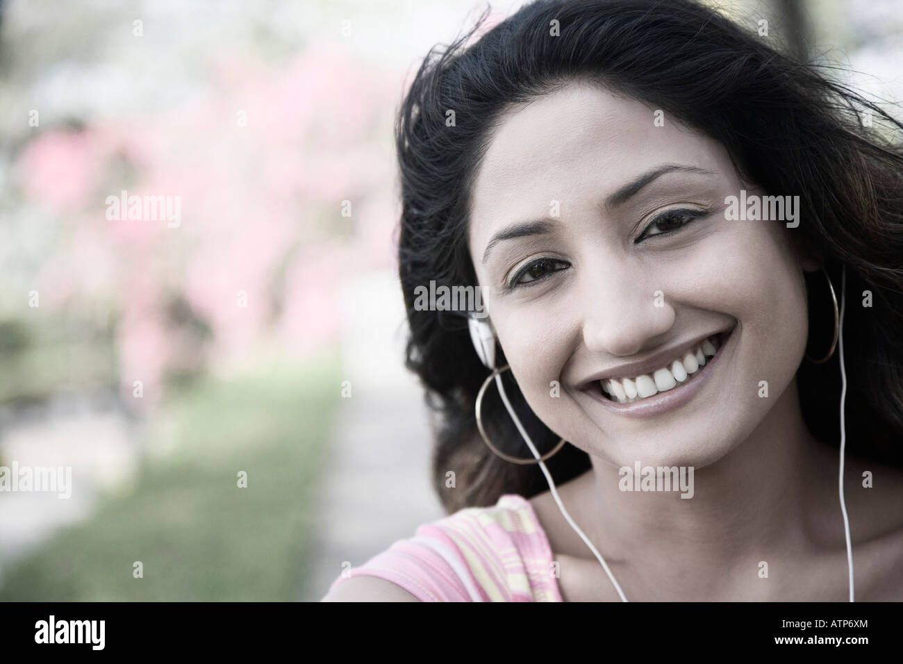 Portrait of a young woman listening to music and smiling Stock Photo ...