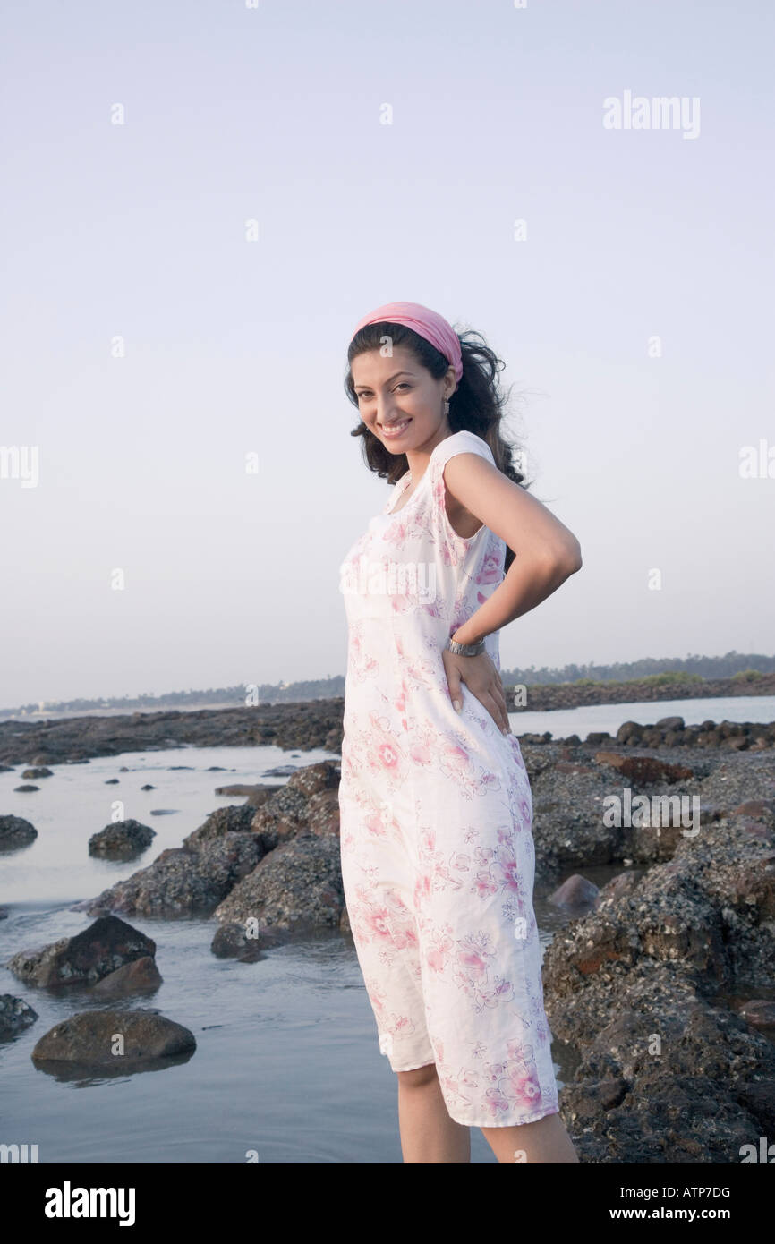 Portrait of a young woman standing on the beach and smiling Stock Photo ...