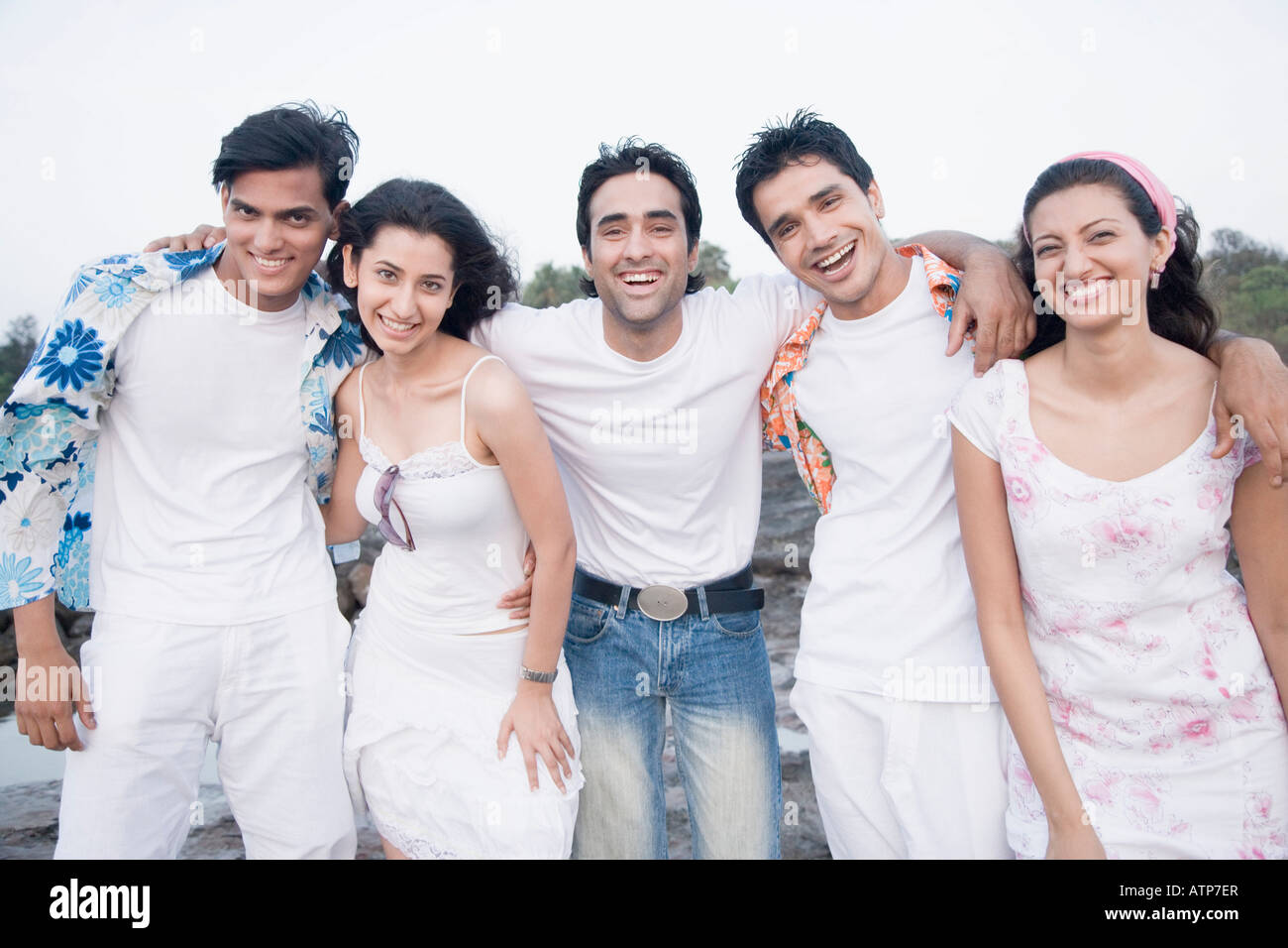 Portrait of three young men and two young women standing together and ...