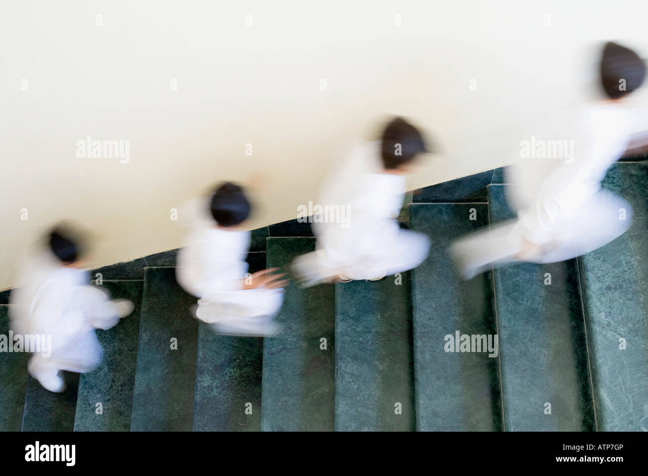 High angle view of four children running on a staircase Stock Photo