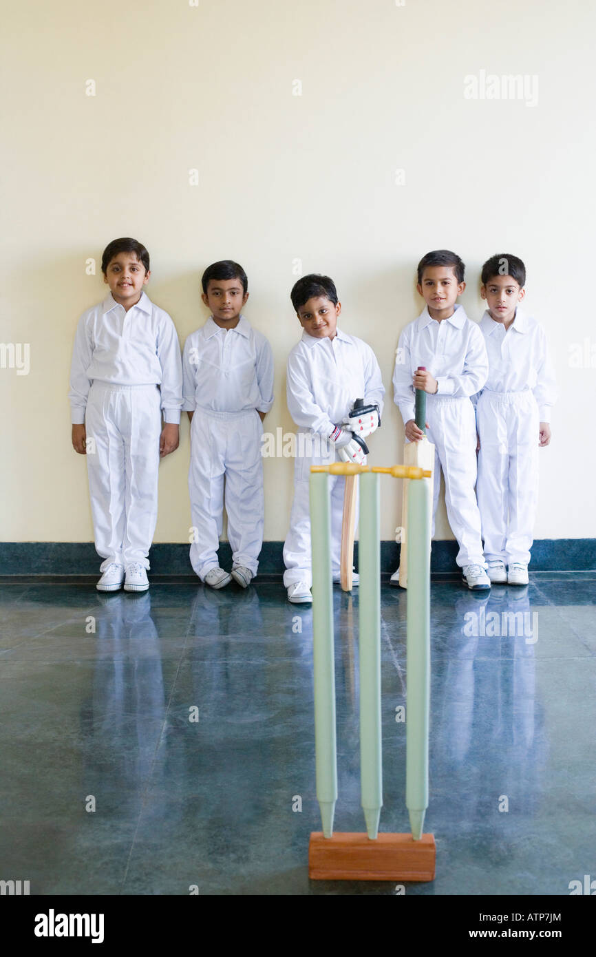 Portrait of five boys standing behind cricket stumps Stock Photo