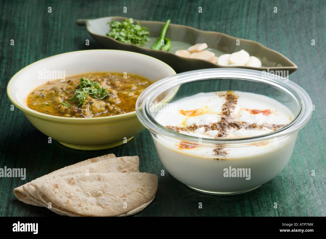 Close-up of a bowl of raita with a bowl of curry and roti Stock Photo