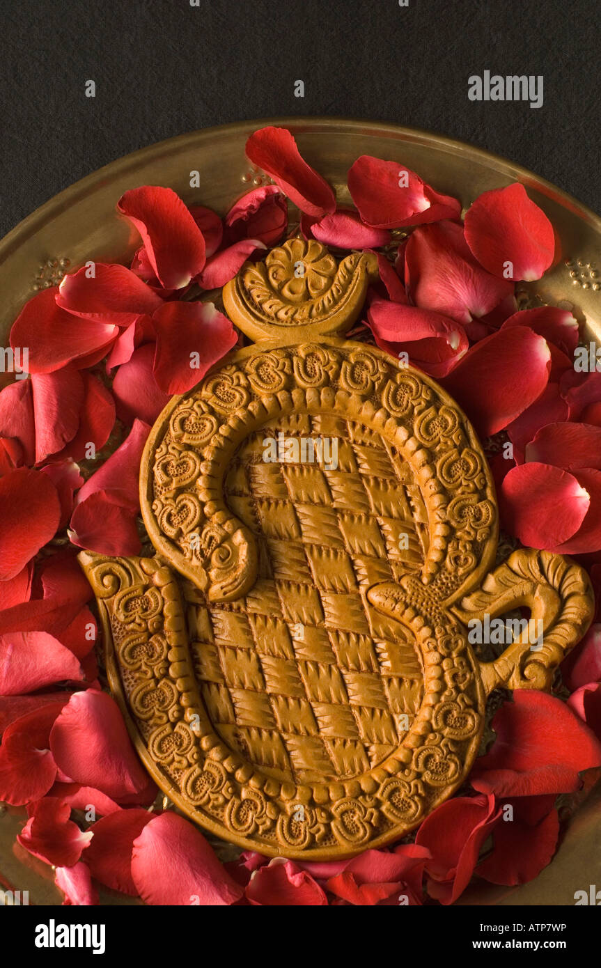 Close-up of a ohm symbol with rose petals in a plate Stock Photo