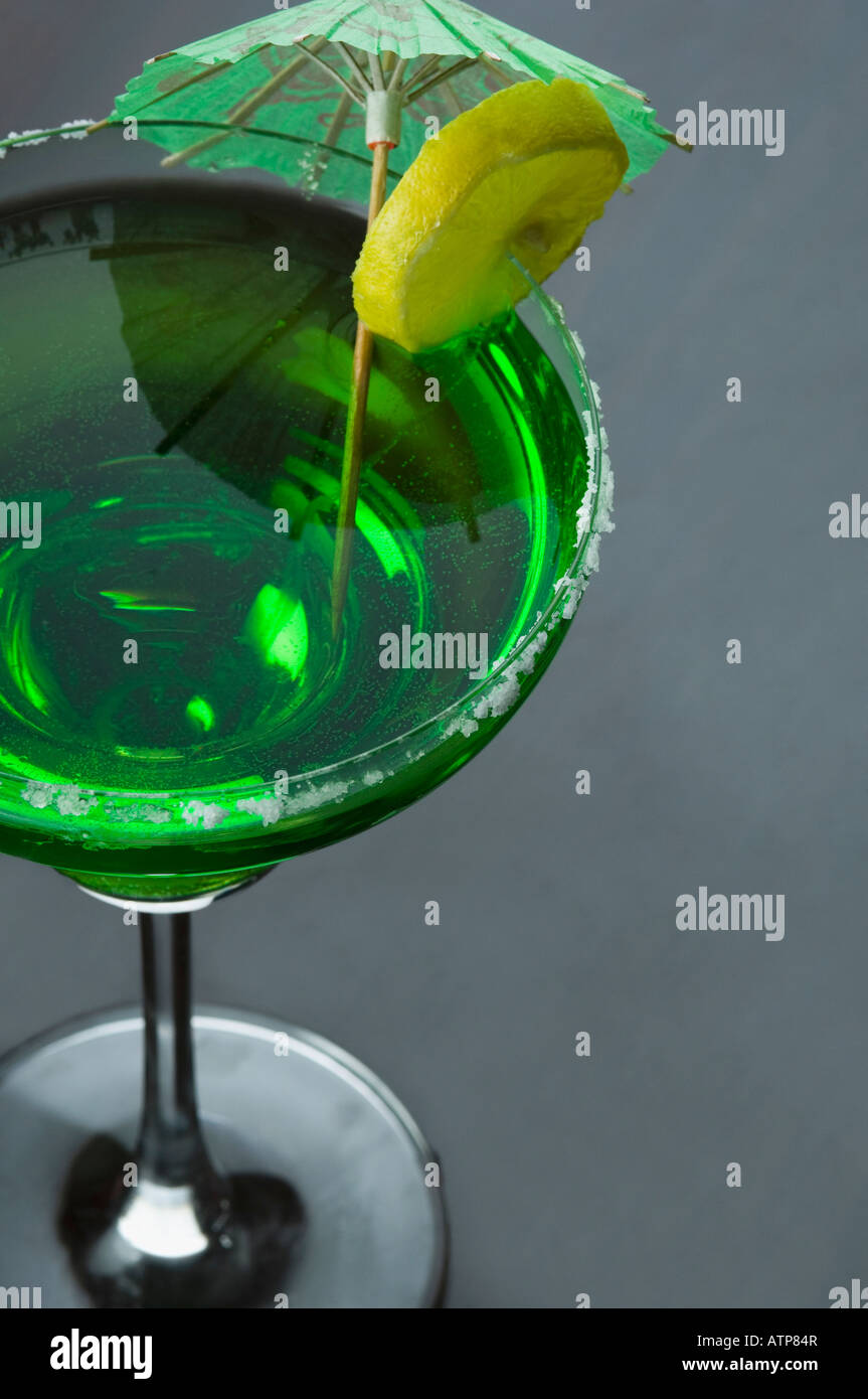 Close-up of a lemon slice and a drink umbrella on a glass of margarita Stock Photo