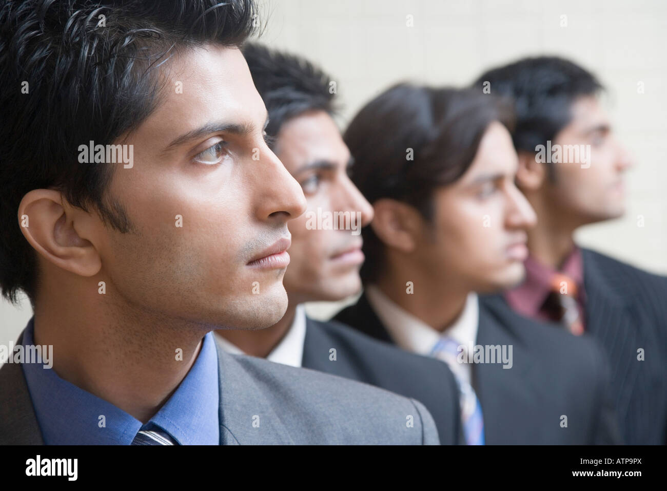 Four businessmen in a row Stock Photo - Alamy