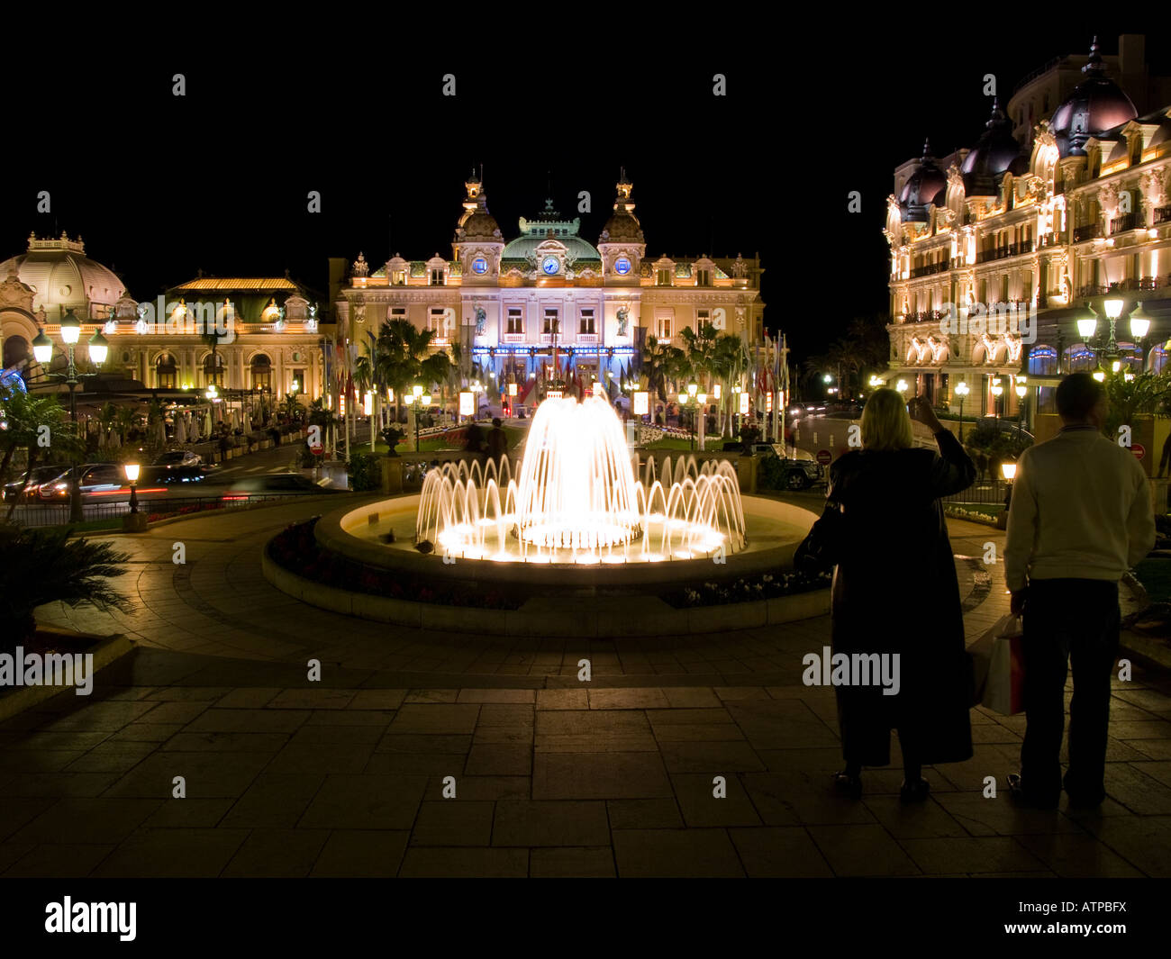 Two tourists and the worldfamous Monte Carlo Casino at night in Monaco
