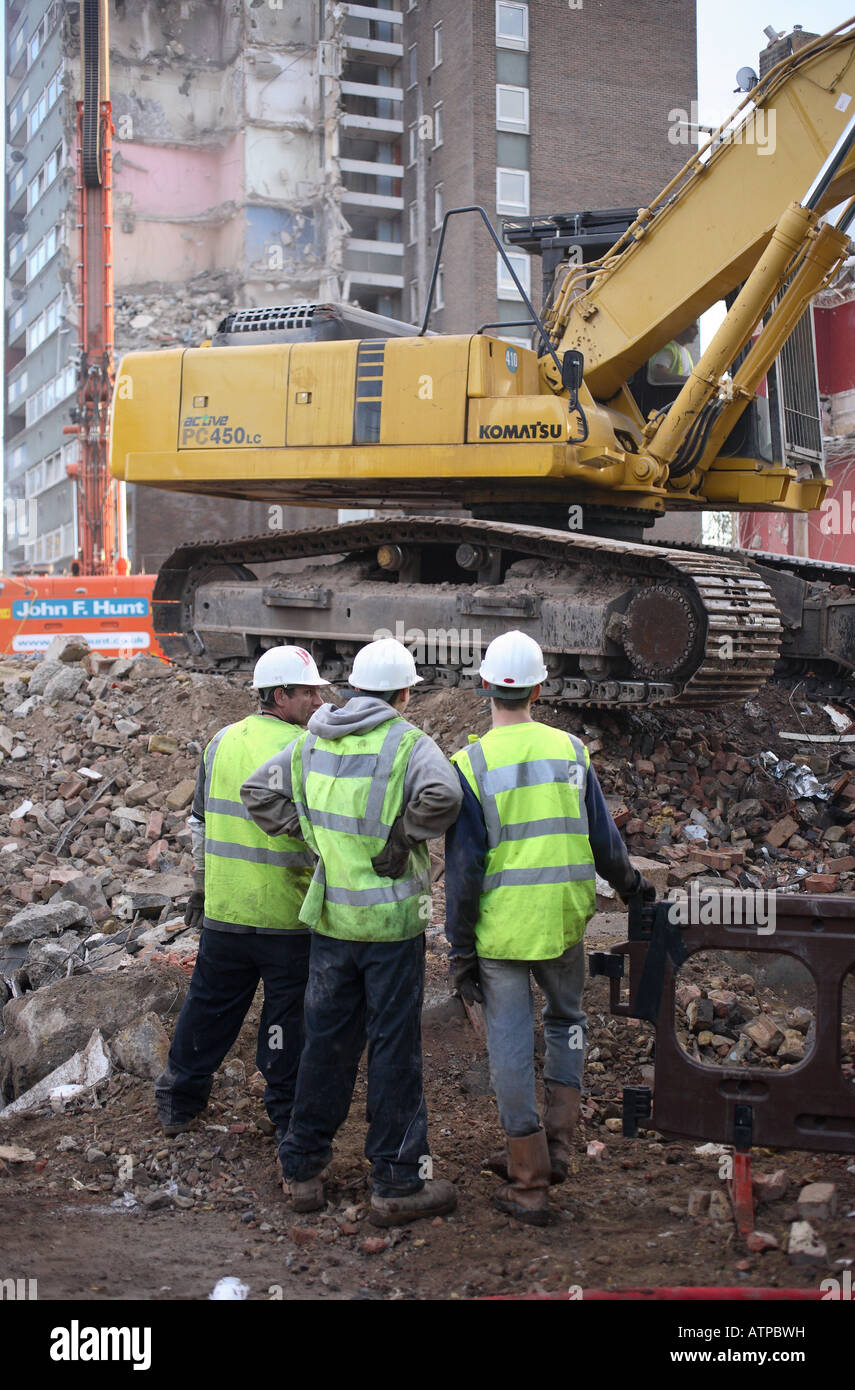Construction workers discuss work on the demolition of a housing estate. Stock Photo
