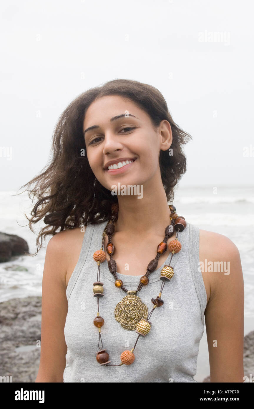 Portrait of a young woman standing on the beach and smiling Stock Photo ...
