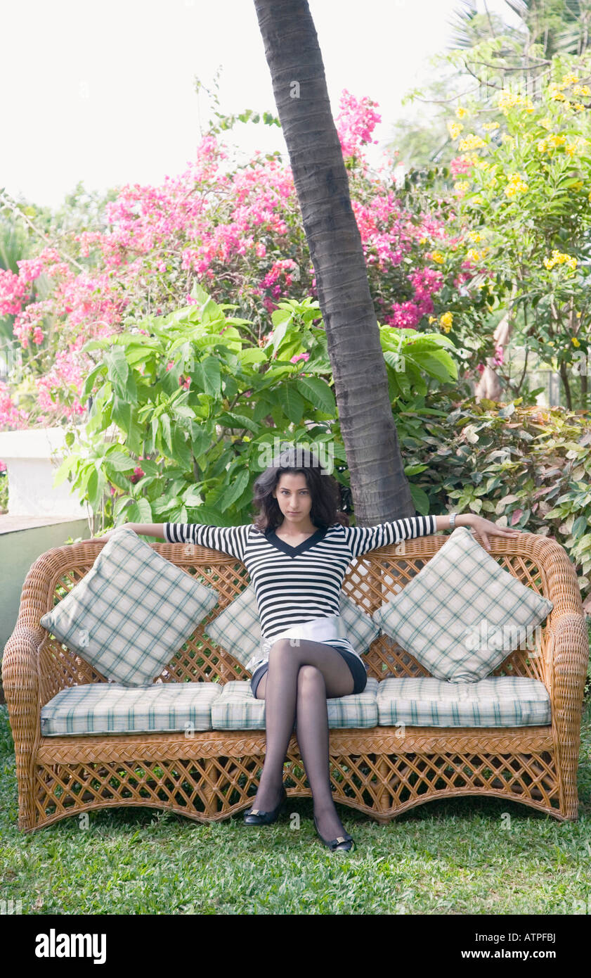 Portrait of a young woman sitting on a couch Stock Photo - Alamy