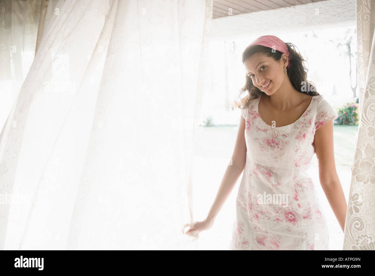 Portrait of a young woman standing and smiling Stock Photo - Alamy