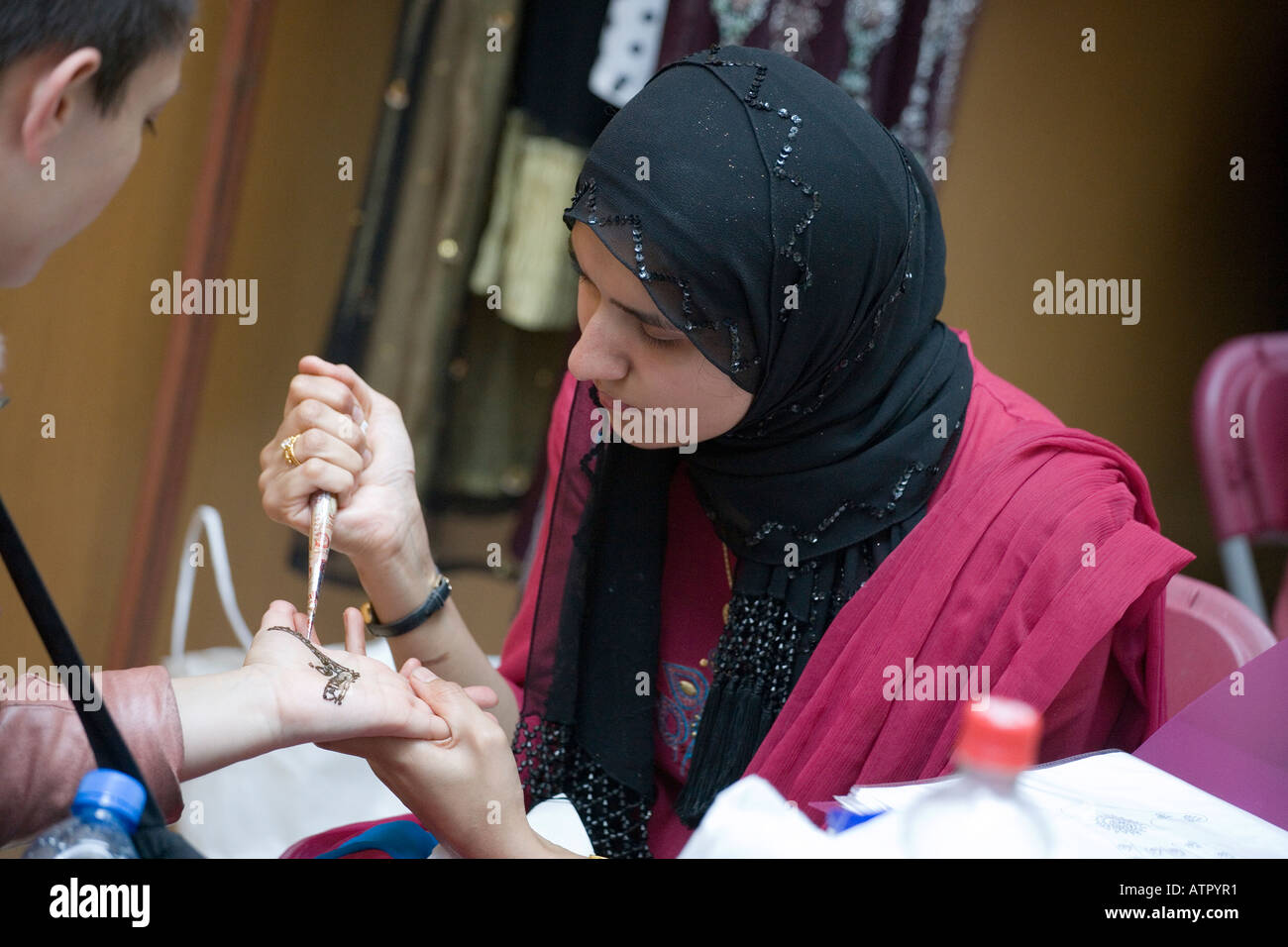 muslim woman applying henna tattoo Stock Photo
