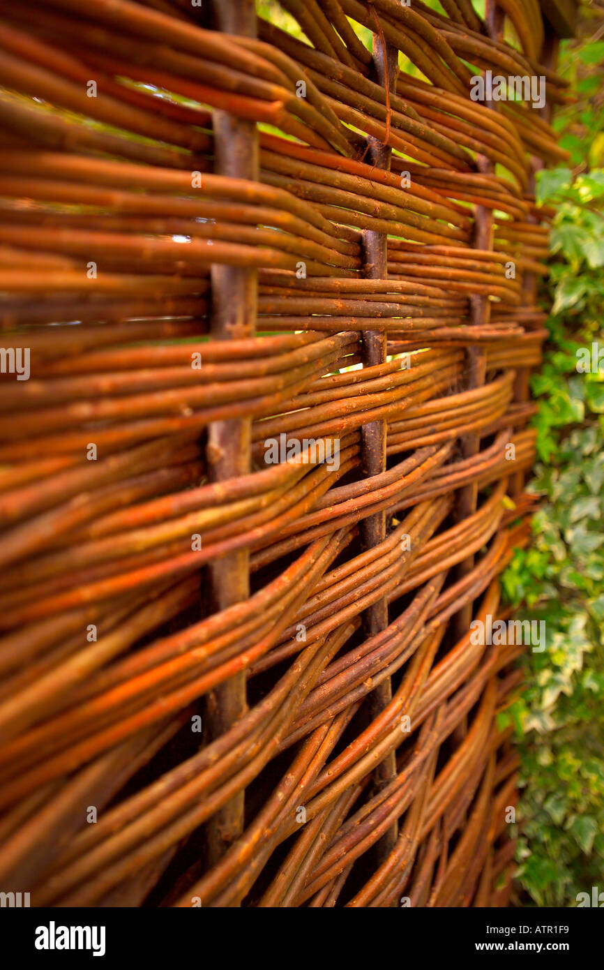 Close up vertical photo of wicker fencing in garden with out of focus