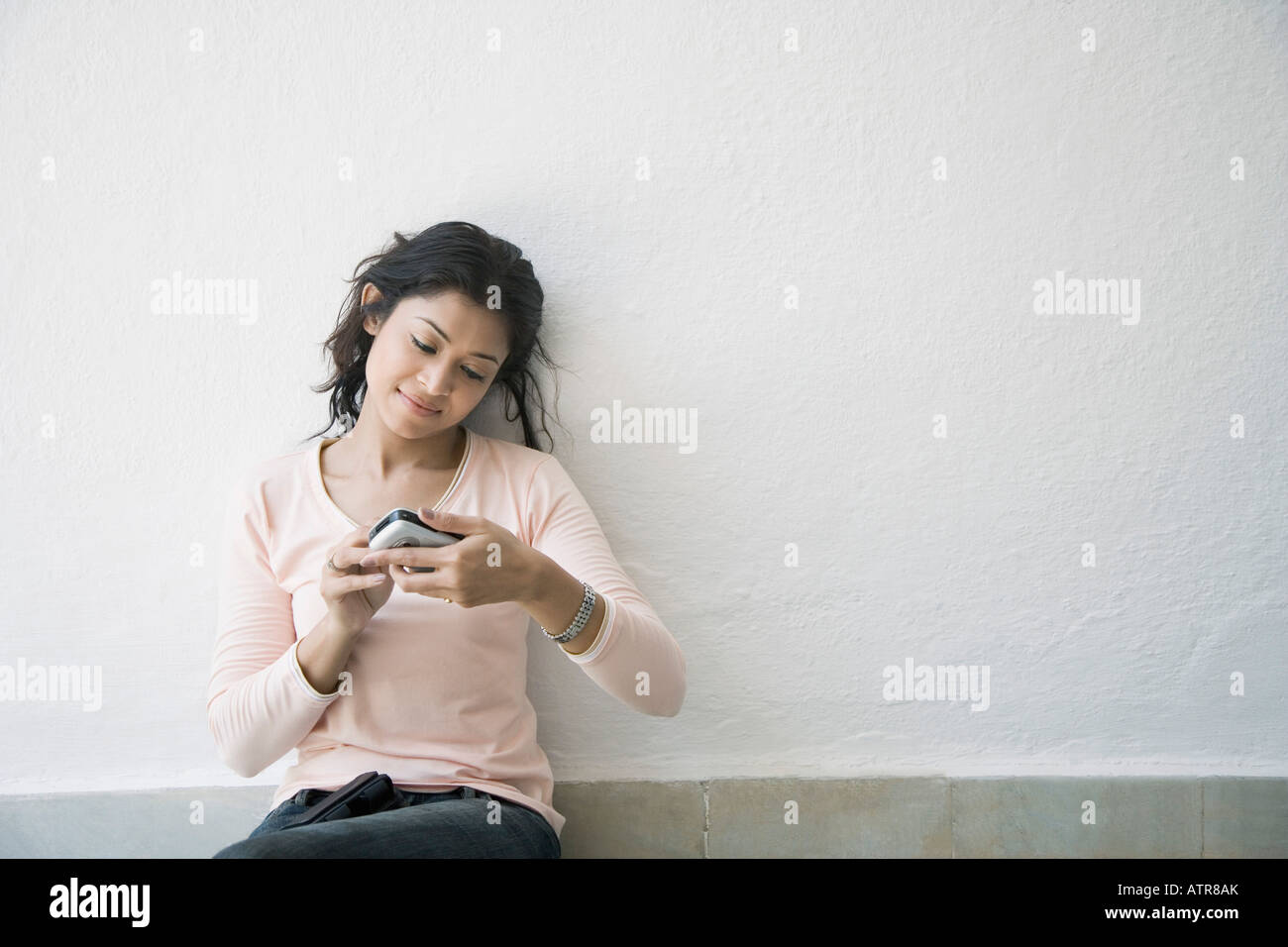 Young woman sitting on the floor and using a mobile phone Stock Photo ...