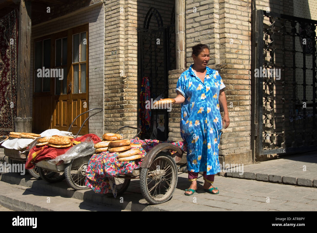 Uzbek woman selling bread in the street of Bukhara Uzbekistan Stock Photo