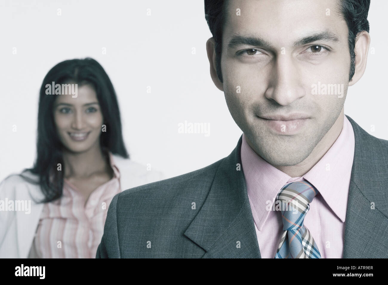 Portrait of a businessman with a businesswoman standing behind him