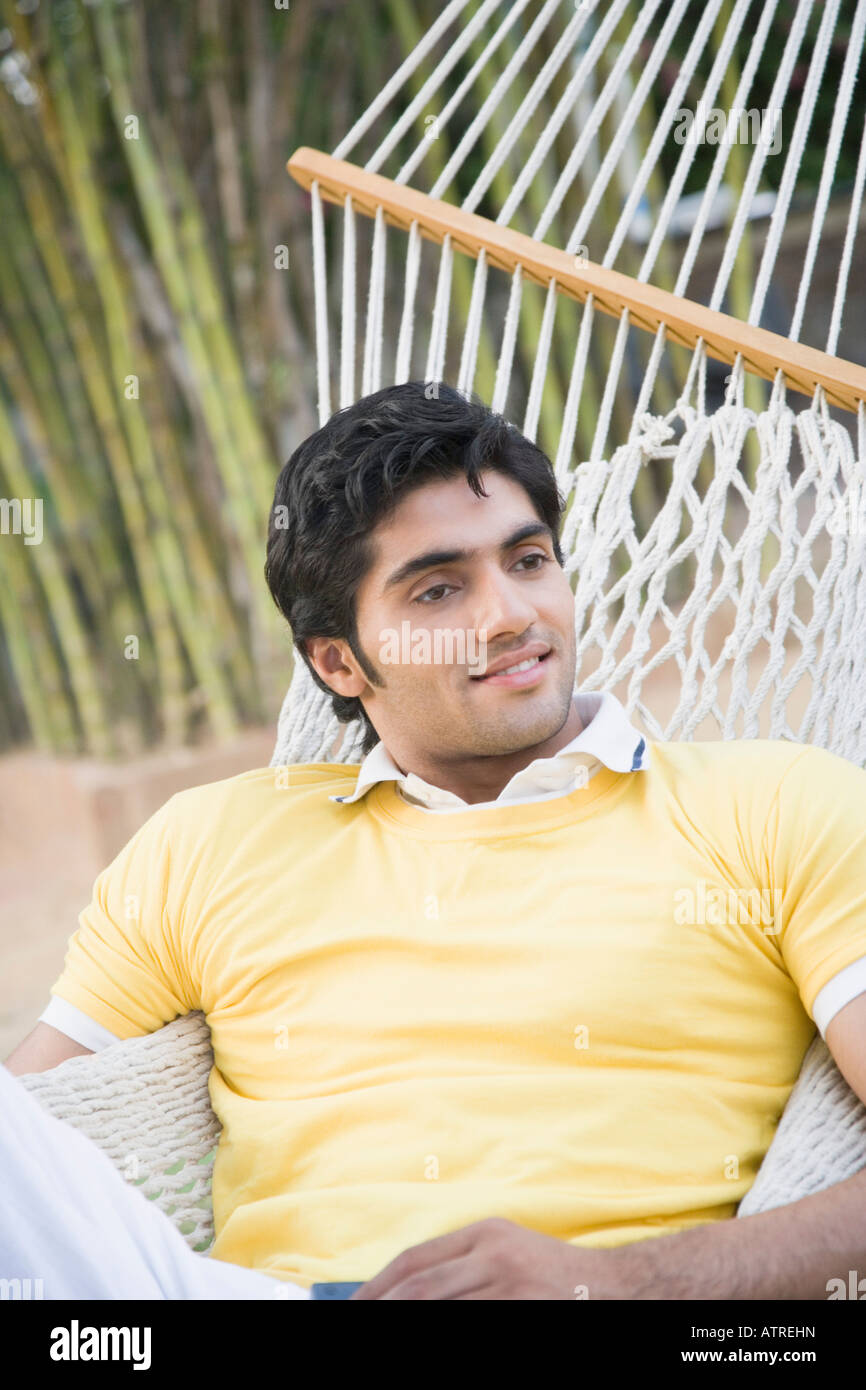 Young man lying in a hammock and smiling Stock Photo