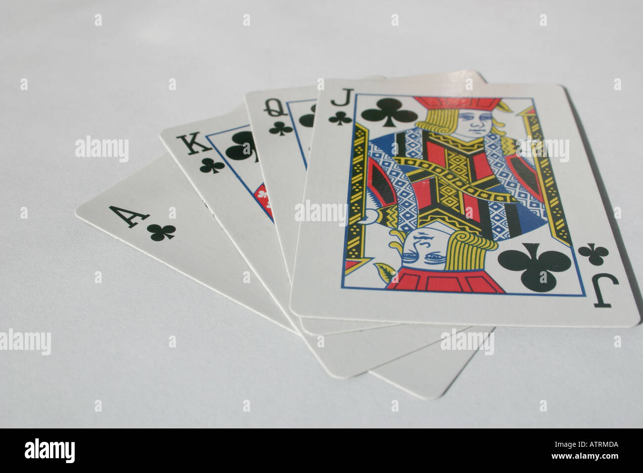 Ace, King, Queen and Jack of Clubs playing cards in a fan shape on a