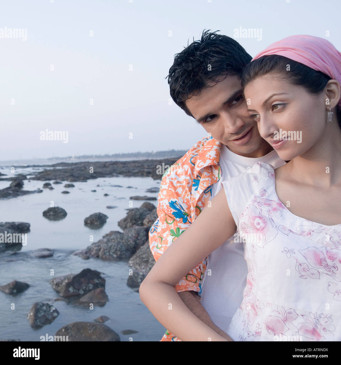 Close-up of a young man embracing a young woman from behind Stock Photo ...