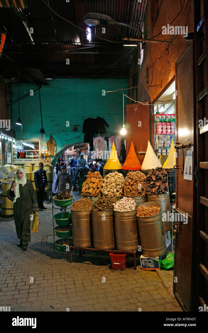 A Moroccan woman walks past a colourful spice shop Kissaria el Jedid