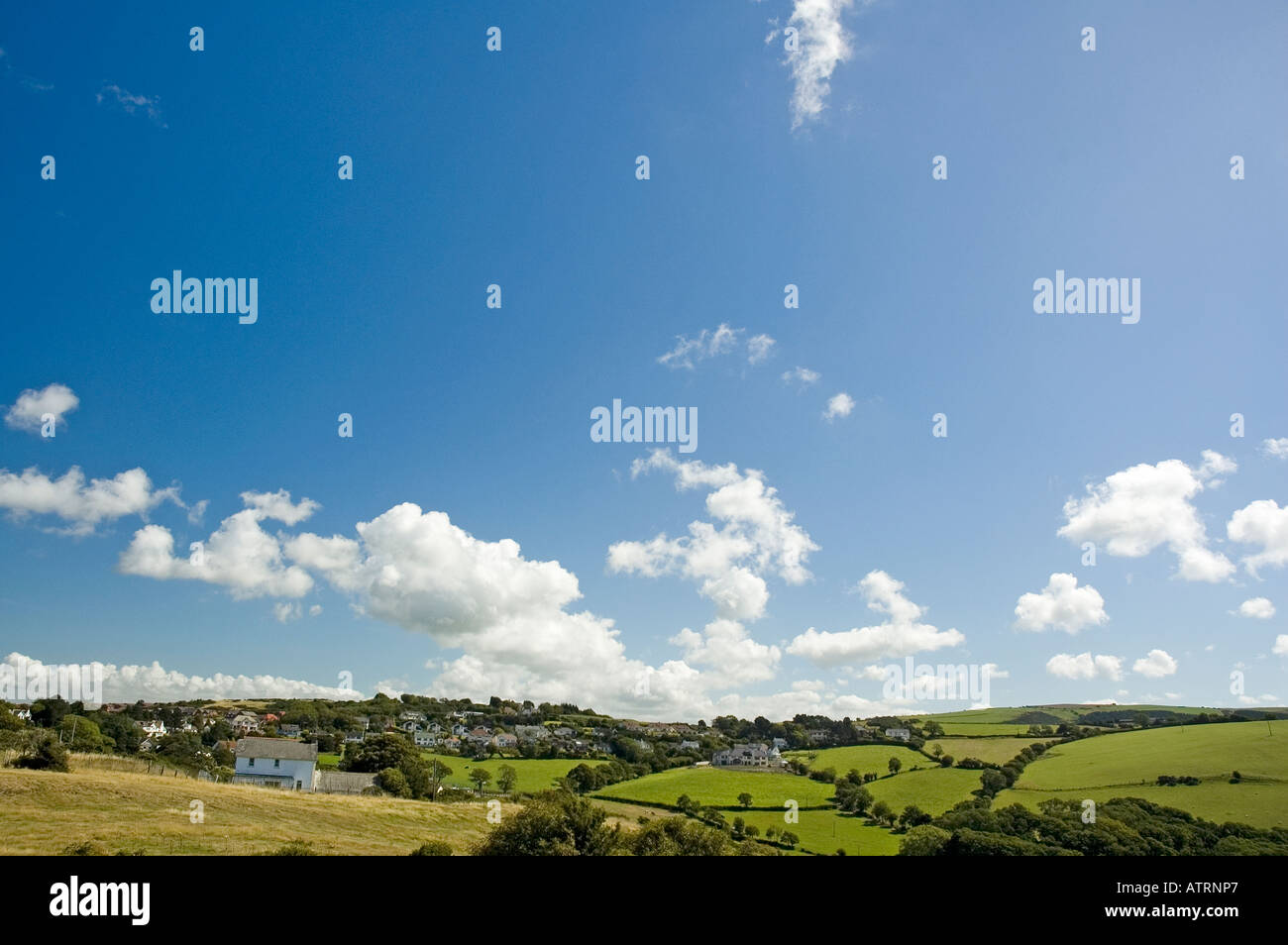 Fluffy white clouds above a countryside landscape Stock Photo - Alamy