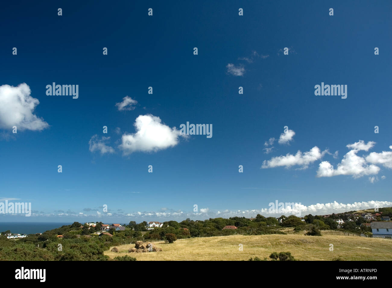 Fluffy white clouds above a countryside landscape Stock Photo - Alamy