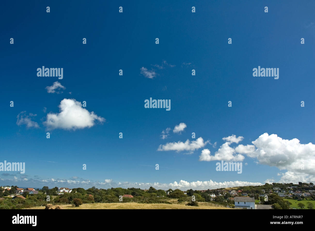 Fluffy white clouds above a countryside landscape Stock Photo - Alamy